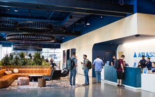 Several Atlassian team members gather at the front desk in the company's office