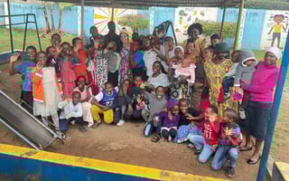 Mallory Boulter poses in a group photo with locals in Tanzania