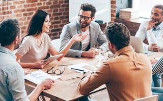 Coworkers having a discussion sitting at a table at the office